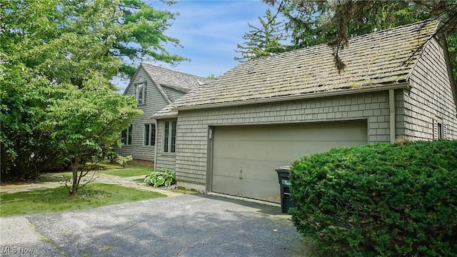 view of property exterior featuring a garage and driveway