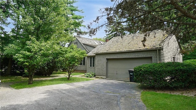 view of home's exterior featuring a garage and aphalt driveway