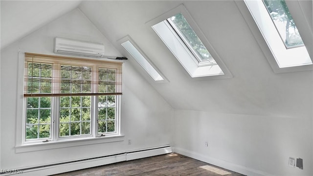 additional living space featuring a baseboard heating unit, vaulted ceiling with skylight, a wall unit AC, and wood finished floors