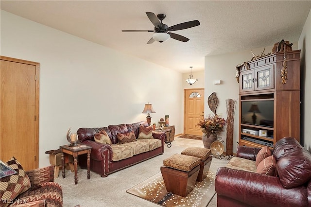 carpeted living room with a textured ceiling and a ceiling fan