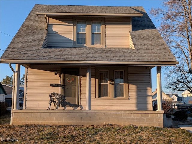 view of front facade featuring covered porch and a shingled roof