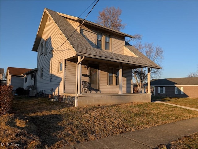 bungalow with central AC unit, a shingled roof, and a front yard