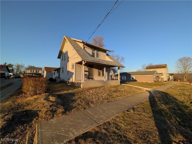 back of property with a yard and a porch