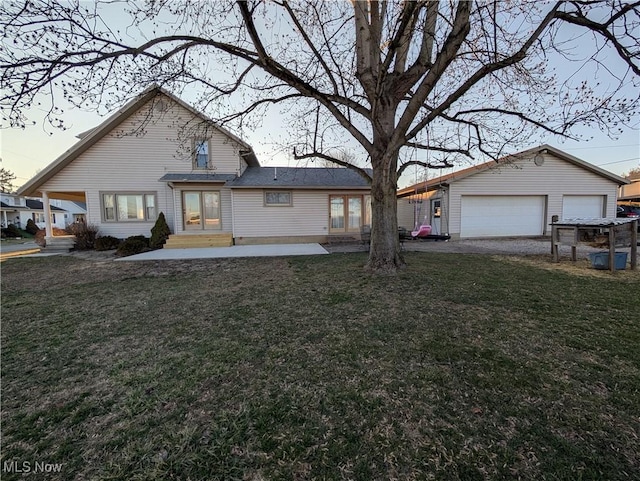 traditional home featuring entry steps, a detached garage, a front lawn, and an outbuilding