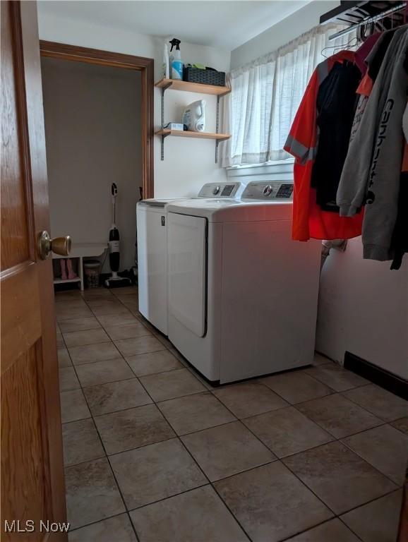 laundry area with light tile patterned floors, laundry area, and washer and clothes dryer