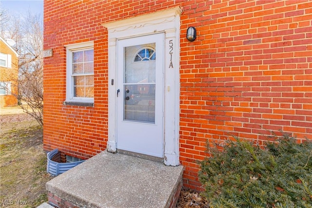 property entrance featuring brick siding