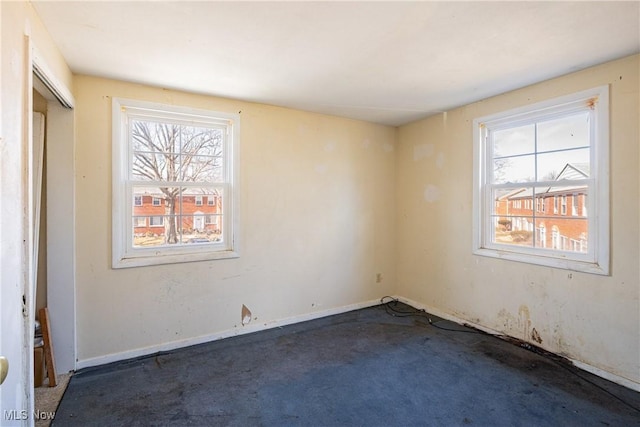 unfurnished room with carpet flooring and baseboards