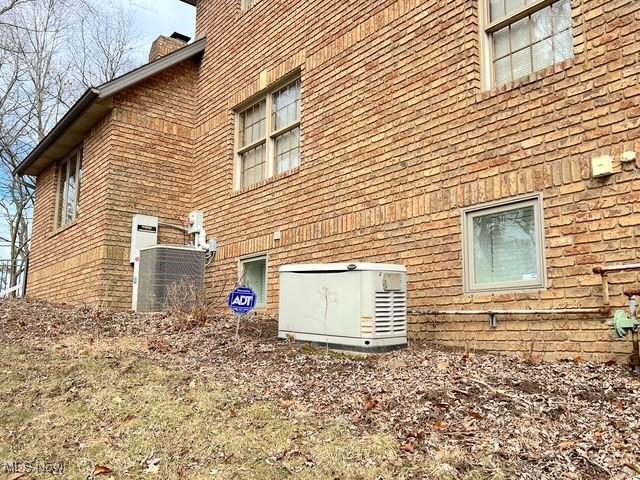 view of side of property with central air condition unit and a chimney