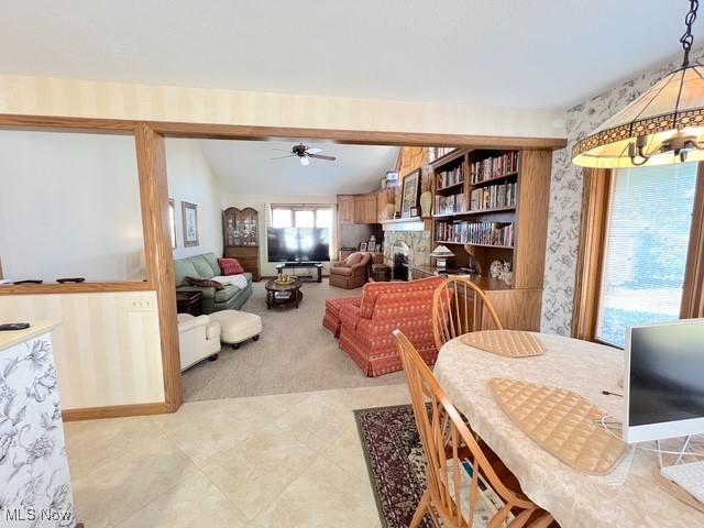 dining room featuring lofted ceiling, light carpet, ceiling fan, and wallpapered walls