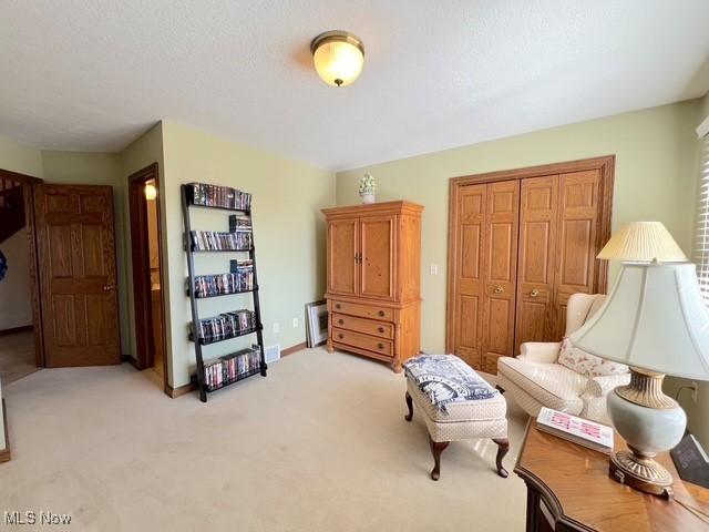 living area with light carpet and baseboards