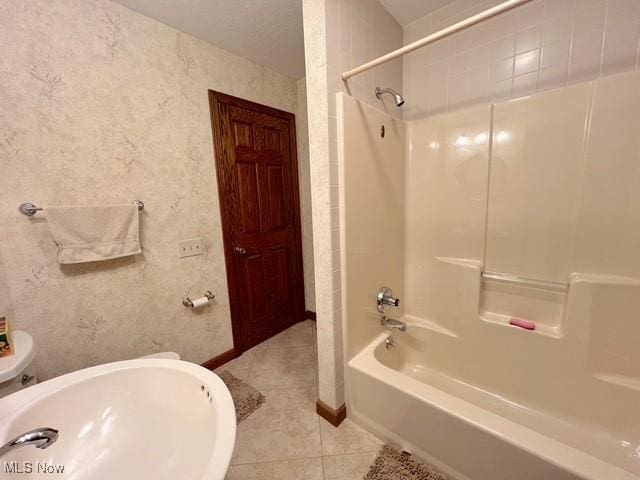 full bathroom featuring tub / shower combination, toilet, baseboards, and tile patterned floors