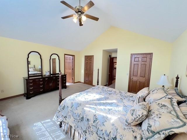 bedroom with light carpet, high vaulted ceiling, ceiling fan, and baseboards