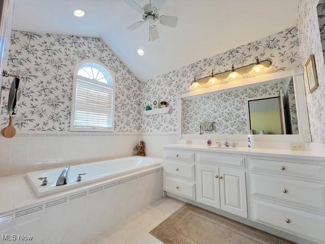 bathroom with a garden tub, a ceiling fan, vanity, vaulted ceiling, and wallpapered walls