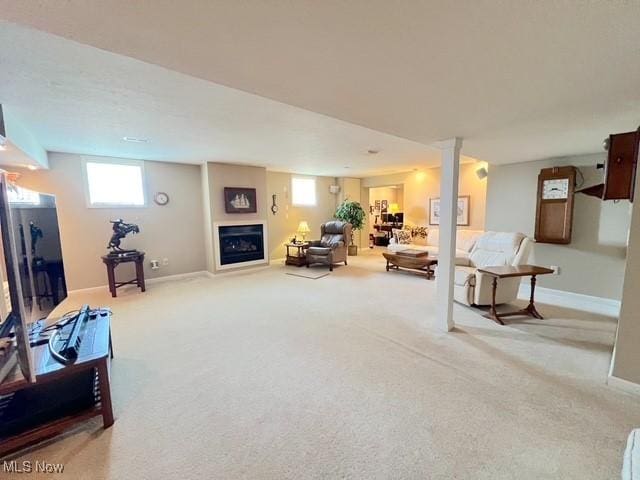 carpeted living area featuring a fireplace and baseboards