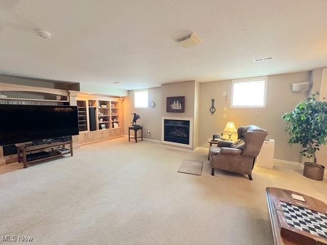 carpeted living room featuring a fireplace and baseboards