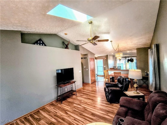 living room with a textured ceiling, ceiling fan, wood finished floors, and lofted ceiling