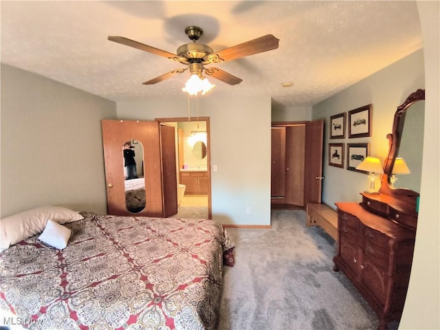 bedroom with a textured ceiling, connected bathroom, a ceiling fan, baseboards, and carpet