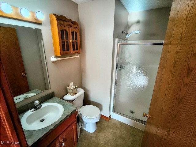 bathroom with toilet, a stall shower, and vanity