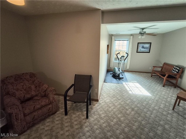 living area featuring carpet floors, ceiling fan, and baseboards