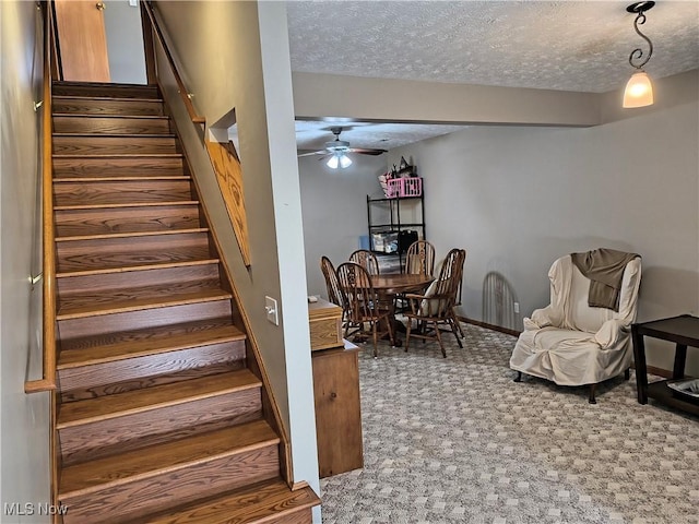 stairway featuring carpet floors, ceiling fan, baseboards, and a textured ceiling