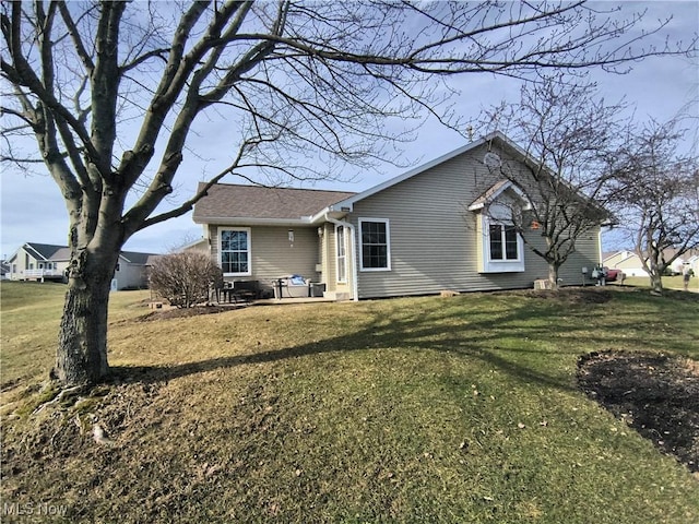 rear view of property featuring a yard