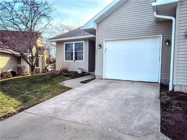 view of front of house featuring driveway, an attached garage, and a front lawn