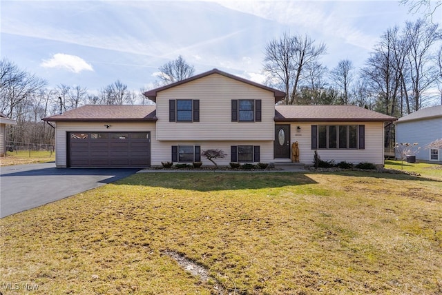 tri-level home featuring aphalt driveway, an attached garage, and a front yard