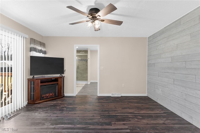 14045 Mahoning Ave, Lake Milton, OH 44451 - unfurnished living room with baseboards, ceiling fan, wood finished floors, a lit fireplace, and wood walls