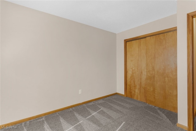 14045 Mahoning Ave, Lake Milton, OH 44451 - unfurnished bedroom featuring a closet, dark carpet, and baseboards