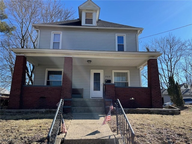 american foursquare style home with covered porch and brick siding