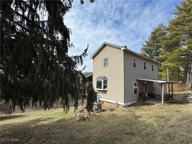 view of home's exterior featuring central AC unit, a lawn, and a patio area