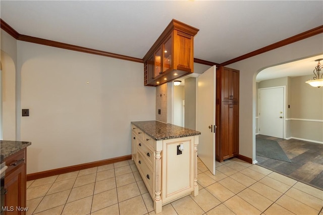 kitchen with arched walkways, crown molding, and light tile patterned floors