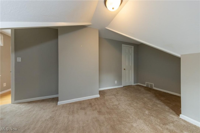 bonus room featuring lofted ceiling, carpet flooring, visible vents, and baseboards