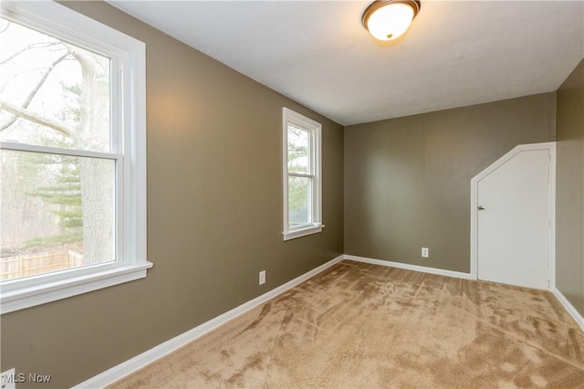 carpeted spare room featuring baseboards