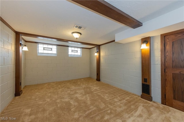 basement with carpet floors, visible vents, and concrete block wall