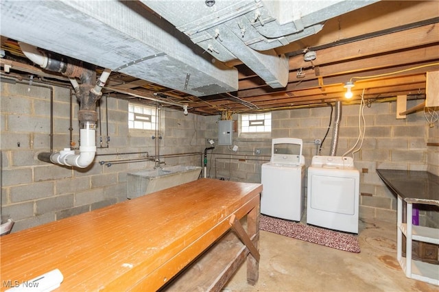 basement with washing machine and dryer, electric panel, and plenty of natural light