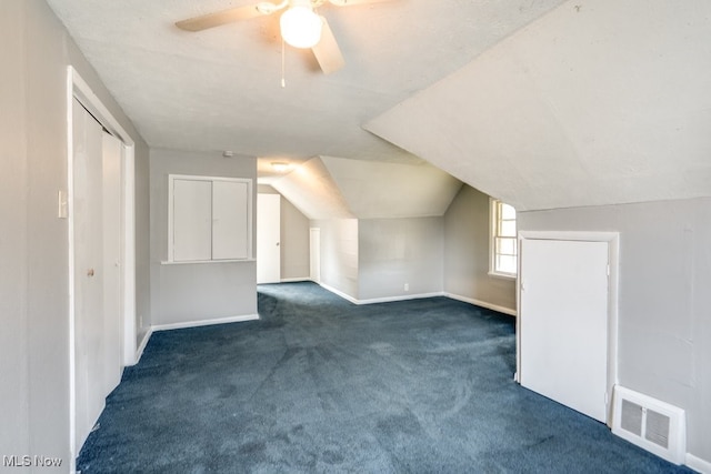 additional living space featuring lofted ceiling, visible vents, a ceiling fan, carpet flooring, and baseboards