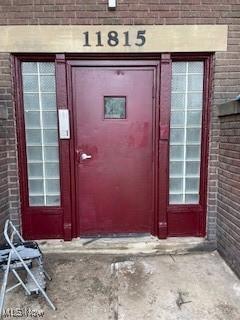 doorway to property with brick siding