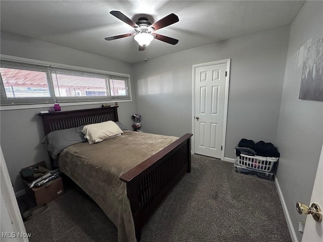 bedroom featuring a ceiling fan, dark colored carpet, and baseboards