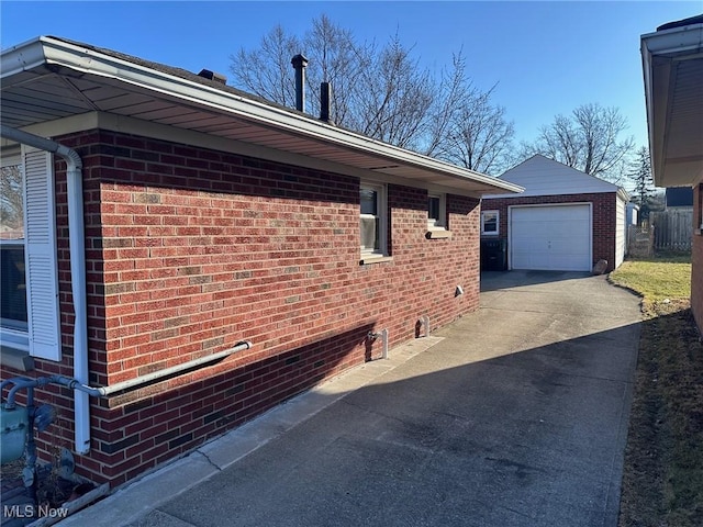 view of home's exterior featuring a garage, concrete driveway, brick siding, and an outdoor structure