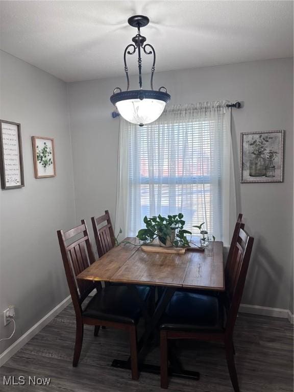 dining space featuring wood finished floors and baseboards