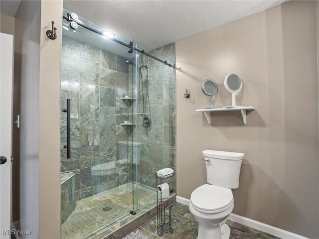 full bath featuring a textured ceiling, a stall shower, toilet, and baseboards