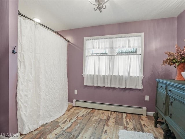 interior space with a baseboard radiator, wood finished floors, vanity, and baseboards