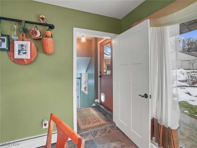 interior space with a baseboard radiator and stone finish floor