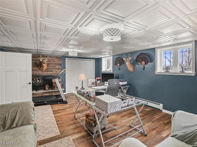 office featuring wood finished floors, an ornate ceiling, and baseboards