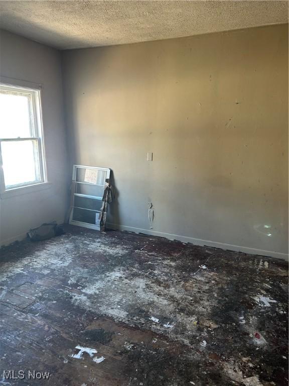 unfurnished room featuring a textured ceiling