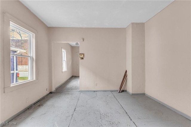 spare room with a wealth of natural light and baseboards
