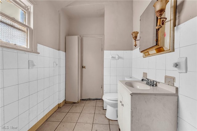 bathroom featuring vanity, toilet, tile patterned flooring, and tile walls