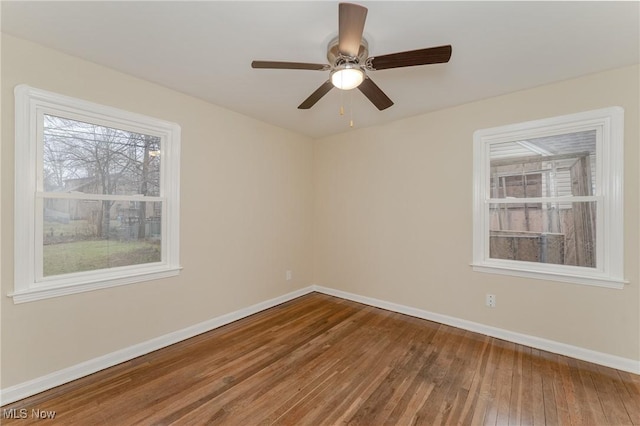 spare room with a ceiling fan, baseboards, and wood finished floors