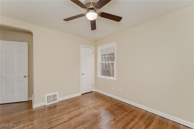 unfurnished bedroom with wood-type flooring, visible vents, ceiling fan, and baseboards